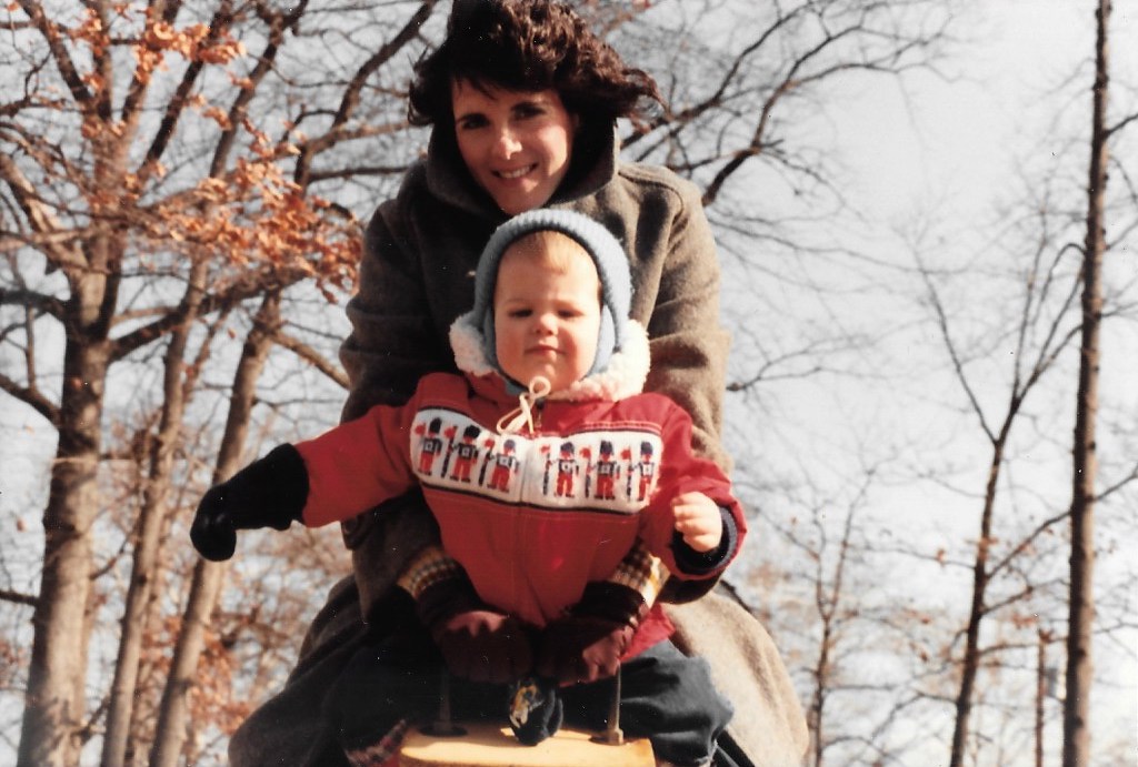 A young Coach Bernadette with a toddler on a see-saw.